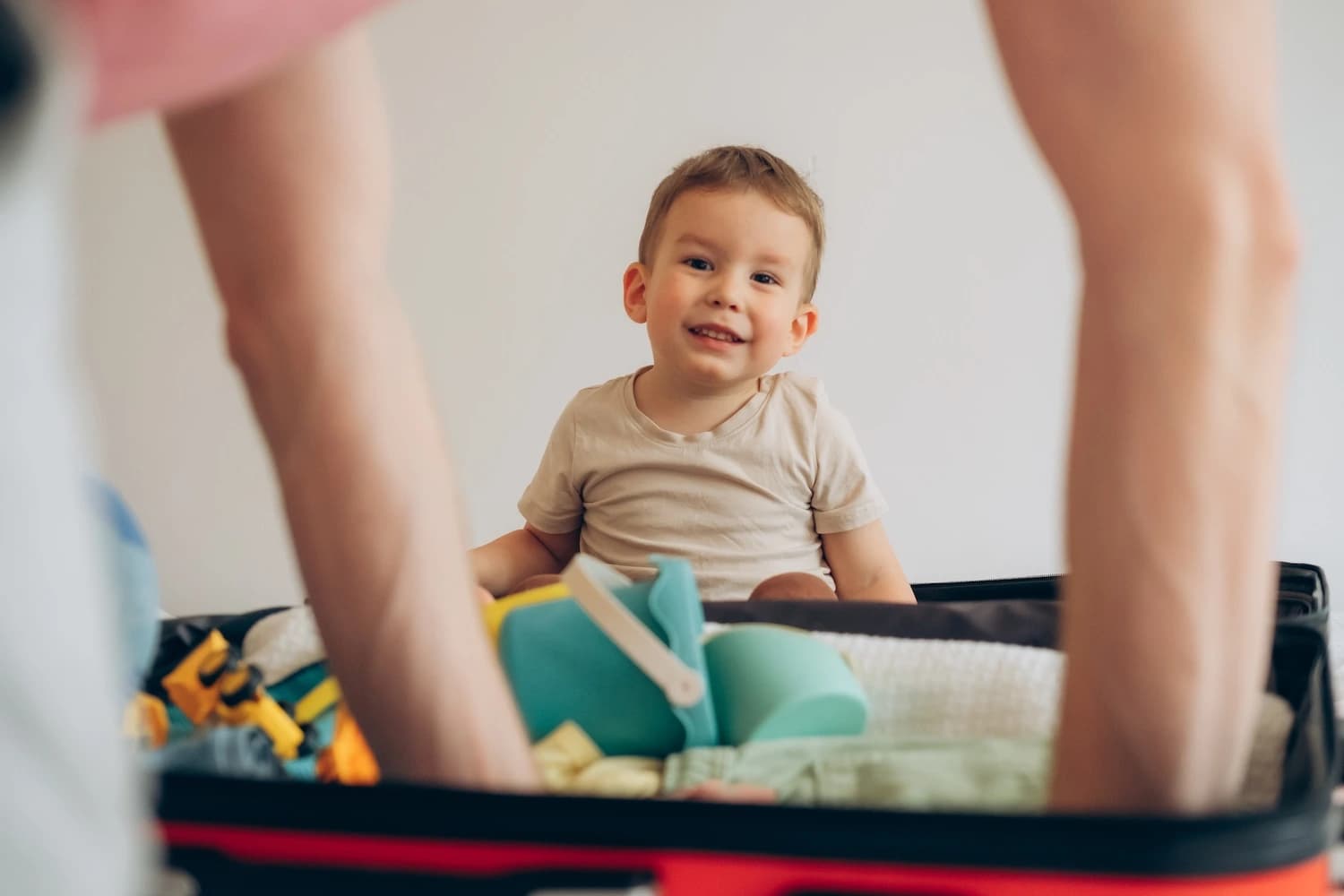 Baby surrounded by travel essentials and packing supplies