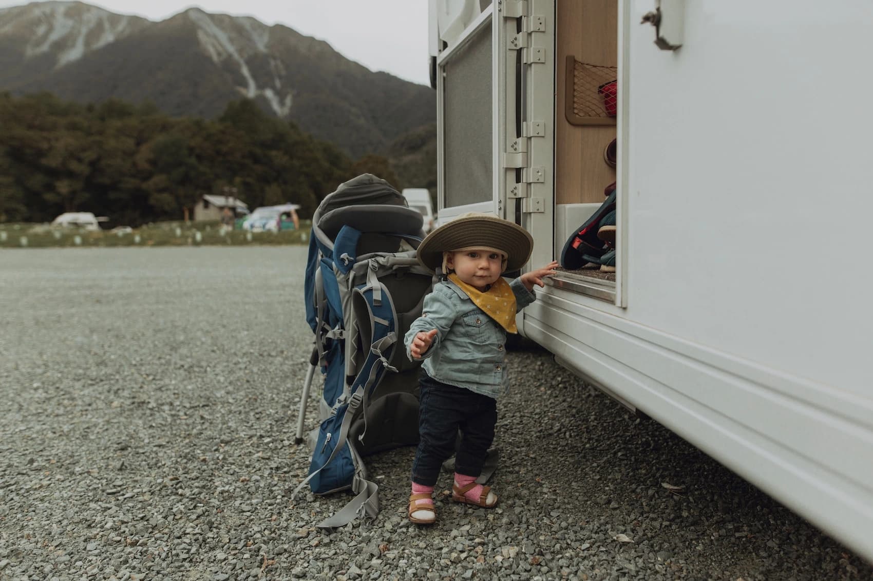 Young child ready for a family road trip adventure beside a motorhome