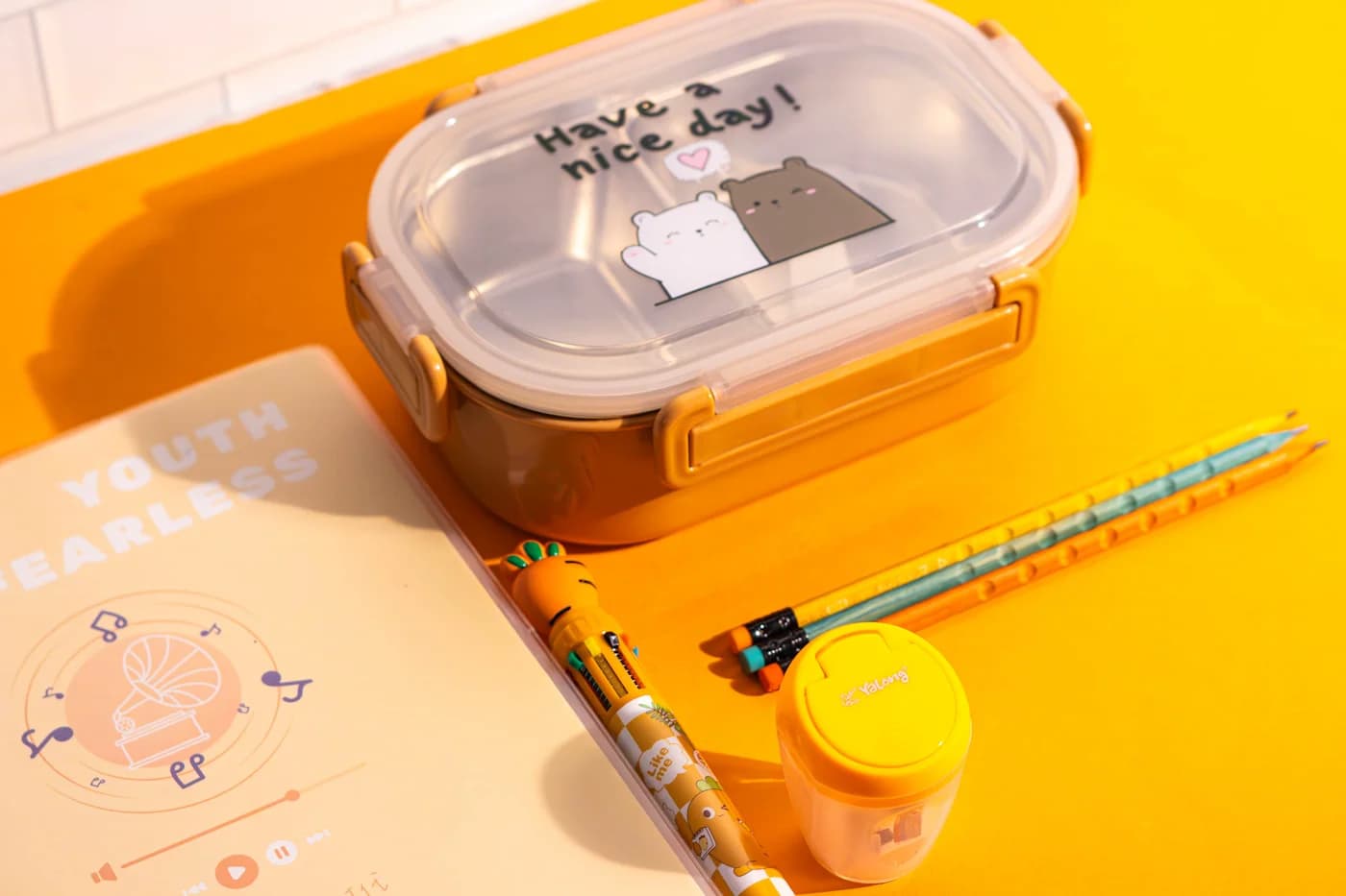 Organized school bag with lunchbox, school supplies and daycare essentials on bright background