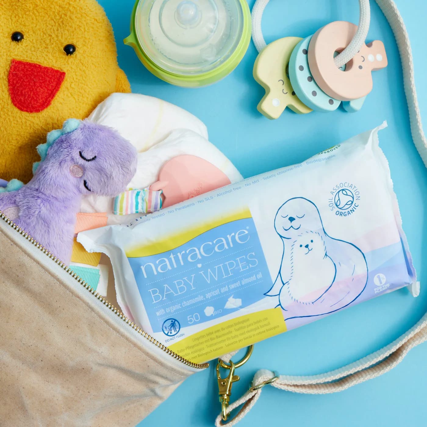 Aesthetically organized diaper bag with diapers, wipes, bottles and pacifier in soft neutral colors
