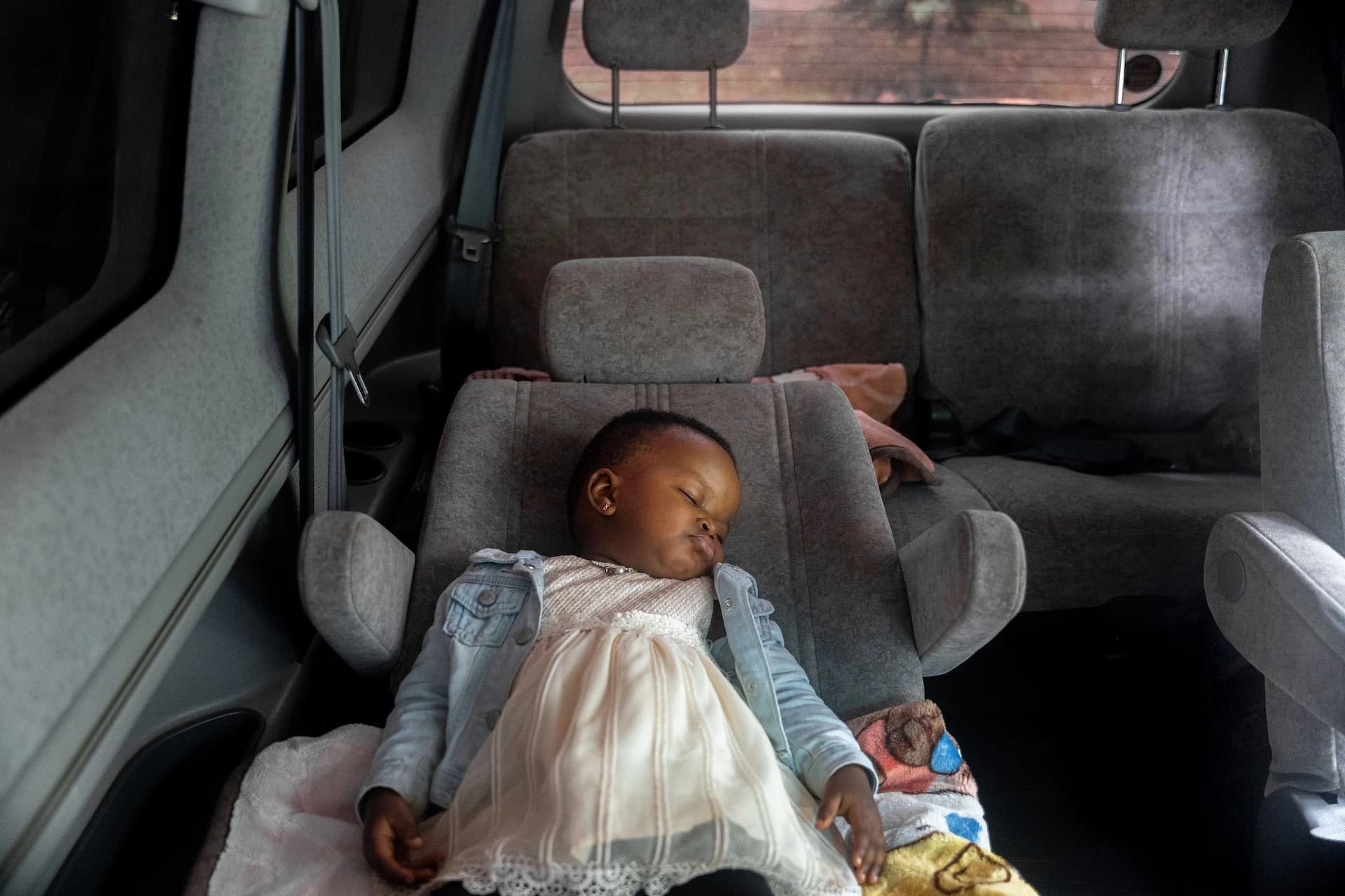 Baby sleeping peacefully in car seat during a family road trip