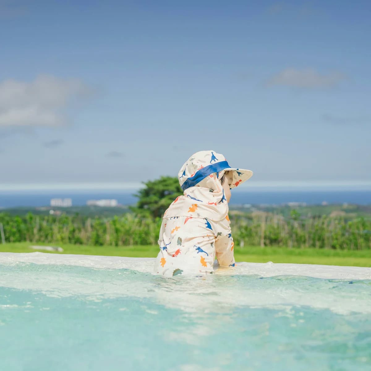 Young child wearing a sun hat while enjoying the water at a swimming pool
