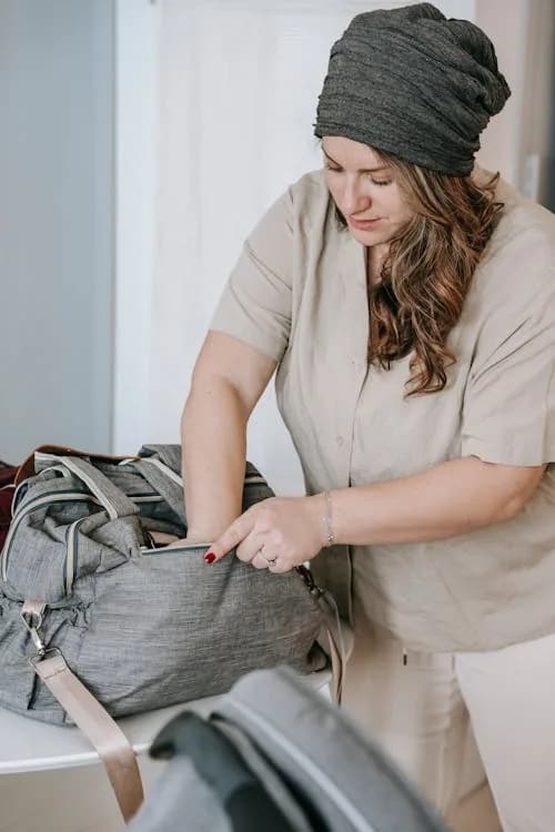 Neatly organized hospital bag with soft robe, slippers, loose clothing, and postpartum recovery items