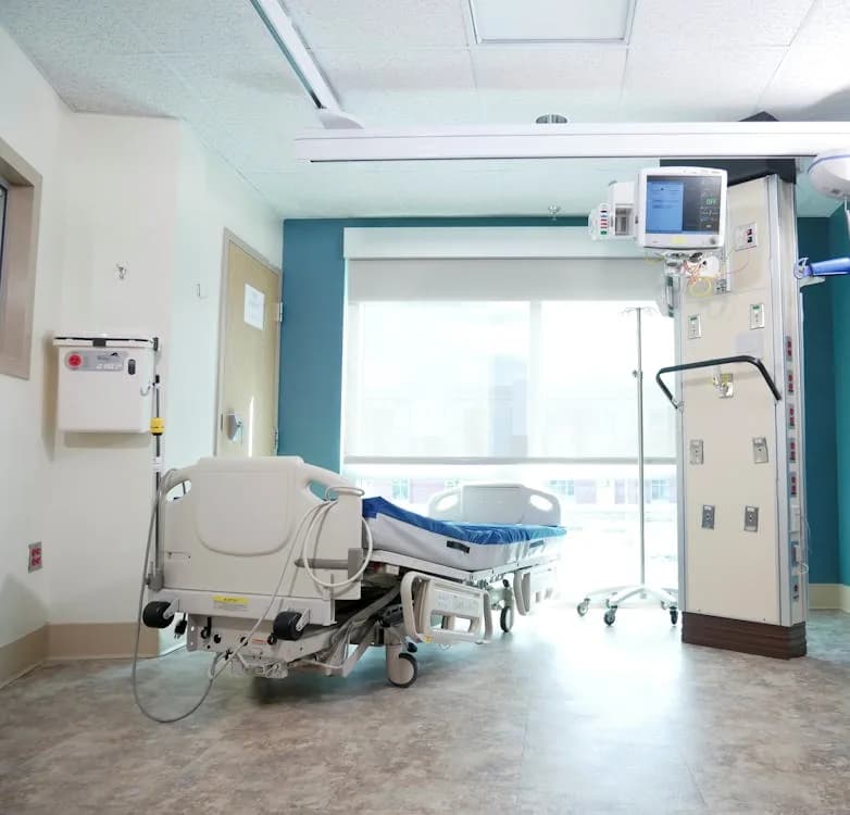 Realistic postpartum hospital room with recovery items and baby bassinet nearby